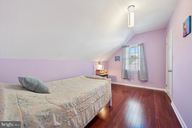 bedroom with vaulted ceiling, hardwood / wood-style floors, and baseboards