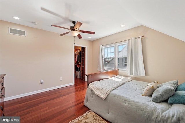 bedroom featuring recessed lighting, wood finished floors, visible vents, a walk in closet, and a closet