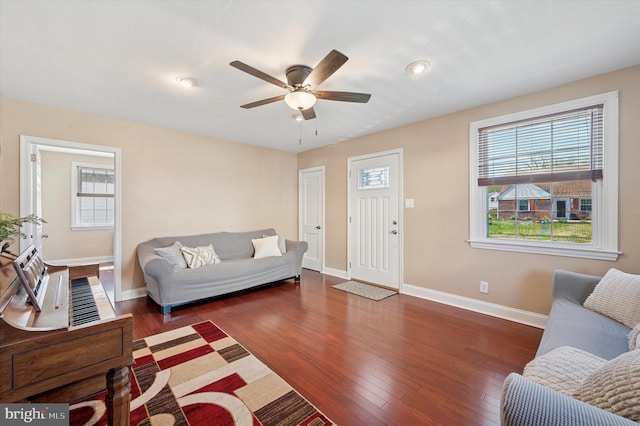 living area with a healthy amount of sunlight, a ceiling fan, and baseboards