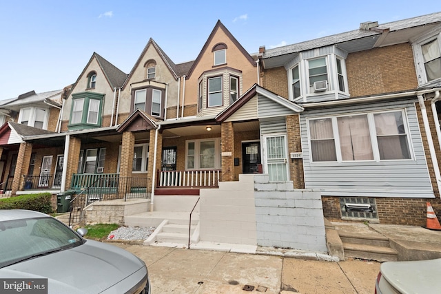multi unit property featuring brick siding and covered porch