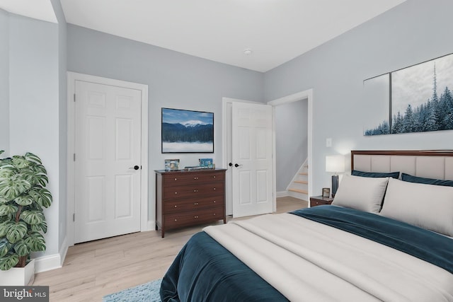 bedroom with light wood finished floors and baseboards