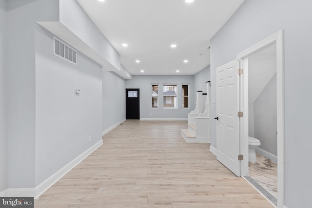 corridor featuring visible vents, baseboards, recessed lighting, and light wood-style floors