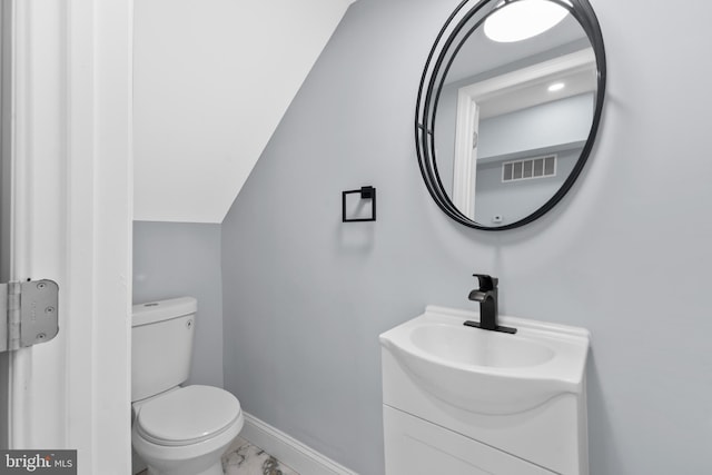 half bathroom featuring vanity, visible vents, toilet, marble finish floor, and baseboards