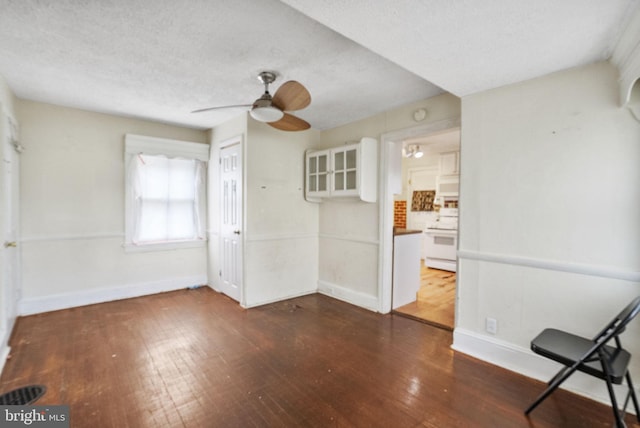 interior space with wood-type flooring, ceiling fan, baseboards, and a textured ceiling
