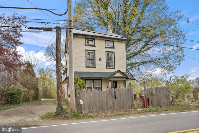 view of front of home with fence and a chimney