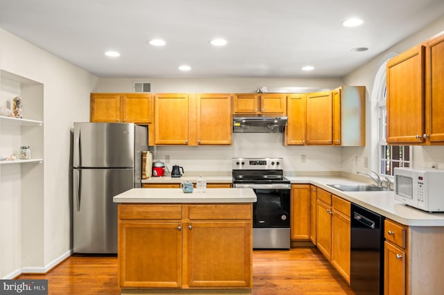 2410 Mallard Ln, Downingtown, PA 19335 - kitchen with under cabinet range hood, visible vents, a sink, light wood-style flooring, and appliances with stainless steel finishes