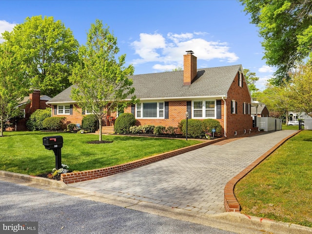 single story home featuring brick siding, a chimney, a shingled roof, and a front yard