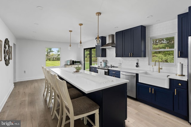 11 Bridge Rd, Lumberton, NJ 08048 - kitchen featuring wall chimney range hood, blue cabinets, a sink, a kitchen bar, and appliances with stainless steel finishes
