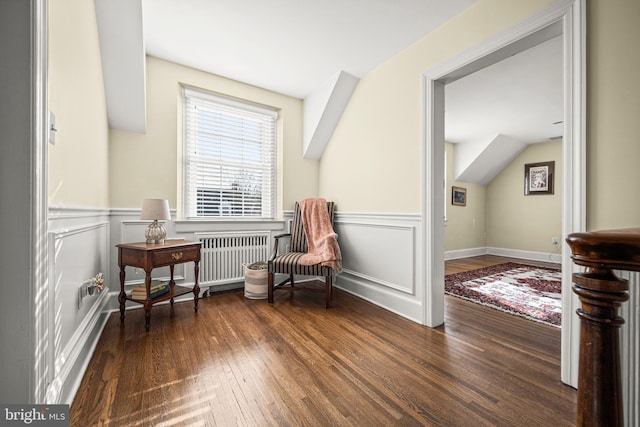 sitting room featuring radiator, a wainscoted wall, a decorative wall, and wood finished floors