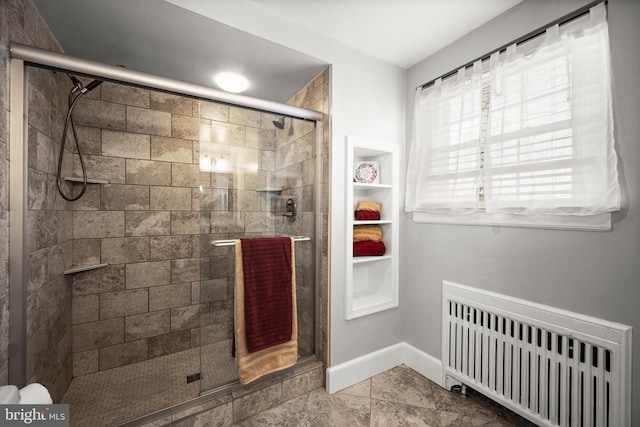 full bath featuring radiator, baseboards, and a stall shower