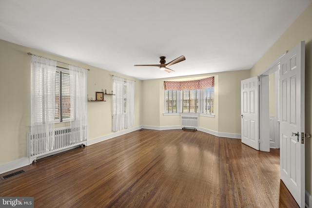 empty room featuring baseboards, ceiling fan, visible vents, and wood finished floors
