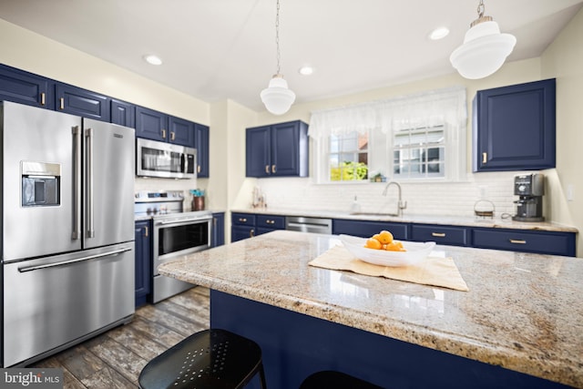 kitchen with a sink, a breakfast bar, stainless steel appliances, and blue cabinets
