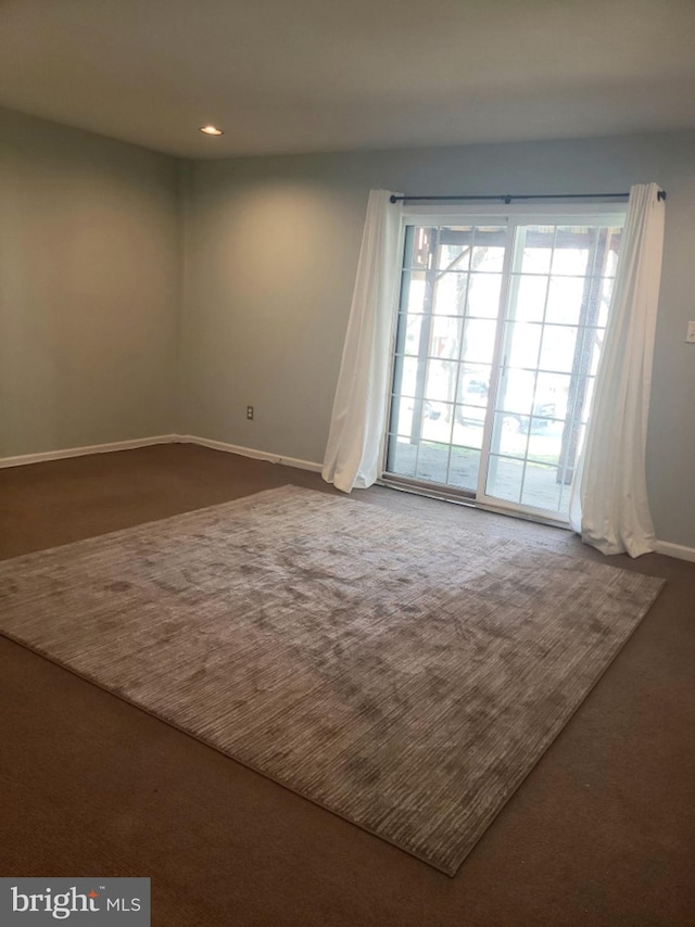 spare room featuring baseboards, dark colored carpet, and recessed lighting