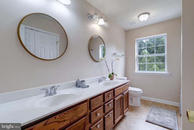 full bathroom featuring a sink, baseboards, toilet, and double vanity