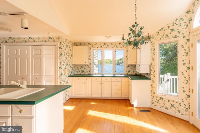 391 Steamboat Rd, Irvington, VA 22480 - kitchen with wallpapered walls, a sink, and vaulted ceiling