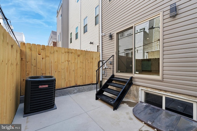 view of patio / terrace featuring entry steps, central AC, and fence