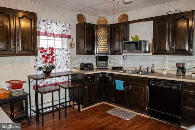 kitchen with stainless steel microwave, dark wood finished floors, dishwasher, a baseboard radiator, and a sink