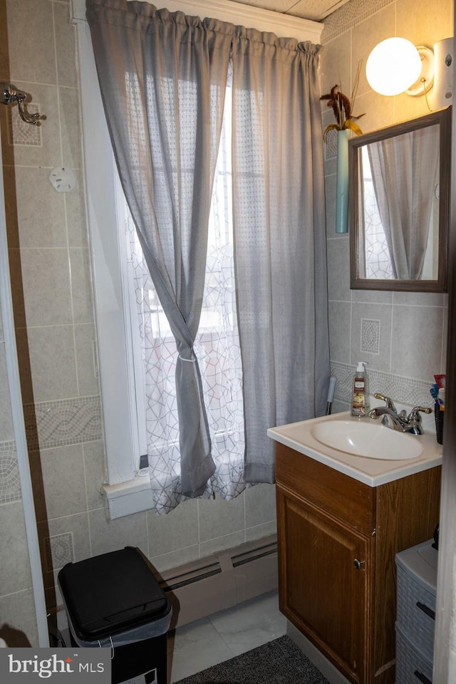 bathroom featuring a baseboard radiator, vanity, tile walls, and backsplash