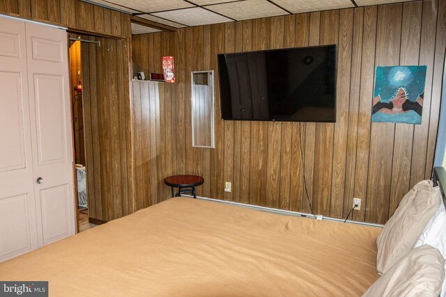 bedroom featuring wood walls