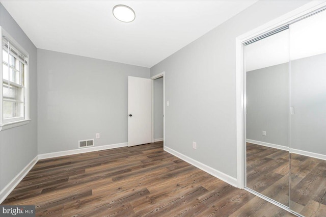 7533 Dover Ln, Lanham, MD 20706 - unfurnished bedroom featuring dark wood-type flooring, a closet, and baseboards