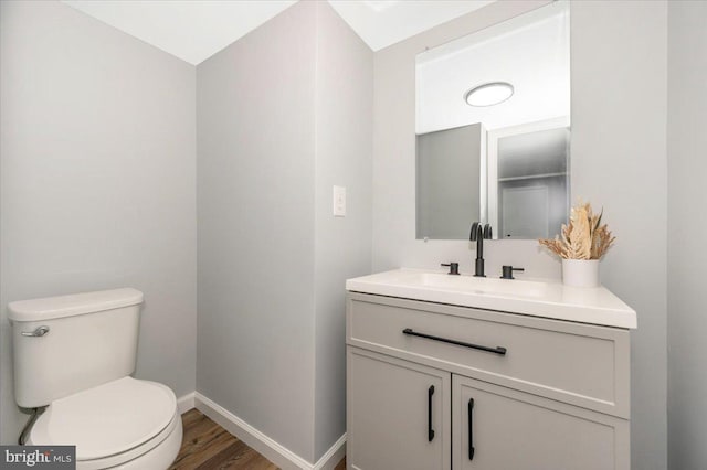 7533 Dover Ln, Lanham, MD 20706 - half bathroom featuring toilet, vanity, baseboards, and wood finished floors