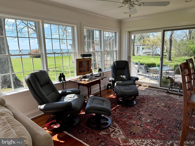 sunroom / solarium with baseboards, crown molding, and wood finished floors
