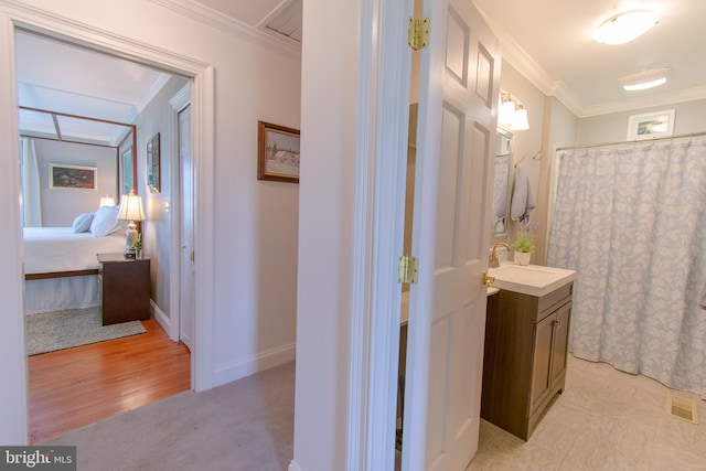 full bathroom with crown molding, vanity, ensuite bath, visible vents, and baseboards