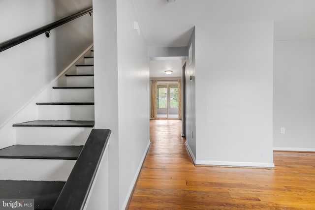 stairs featuring wood finished floors and baseboards