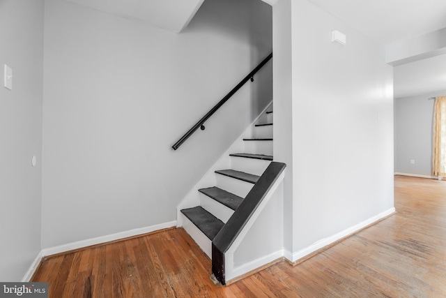 stairs featuring baseboards and wood finished floors