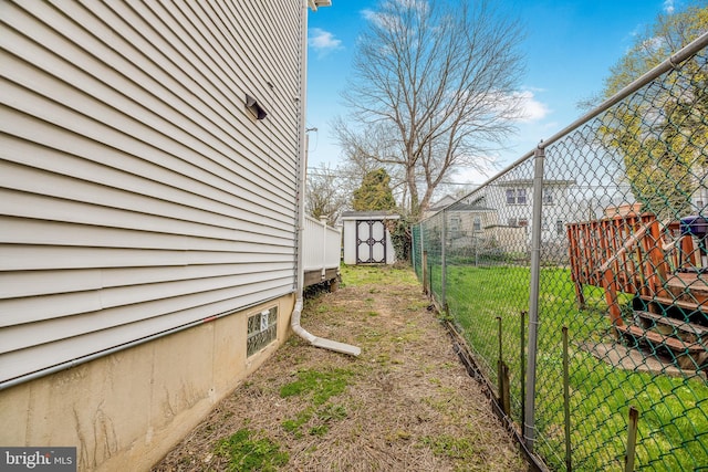view of yard featuring a storage shed, an outbuilding, and fence