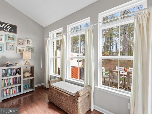 living area with lofted ceiling, wood finished floors, and baseboards