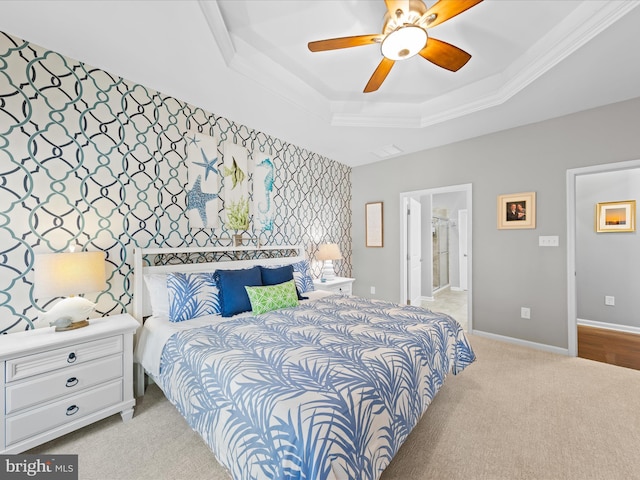 bedroom with a ceiling fan, crown molding, a tray ceiling, light colored carpet, and baseboards
