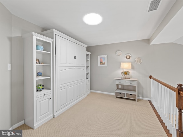 interior space with light colored carpet, baseboards, and visible vents