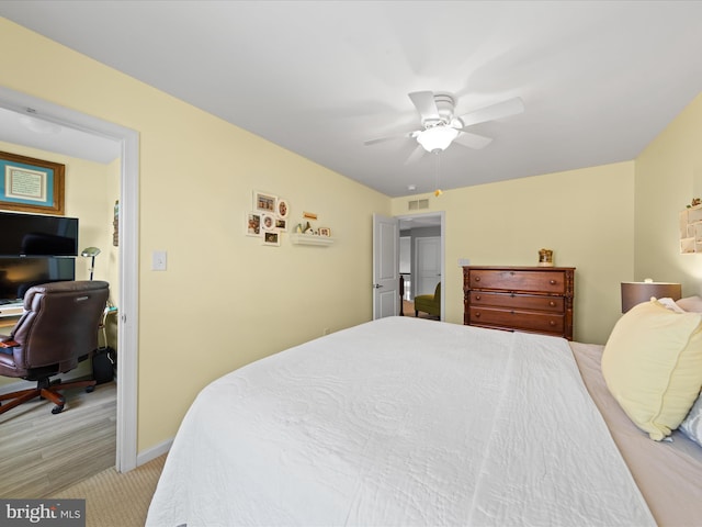bedroom with light colored carpet, ceiling fan, baseboards, and visible vents