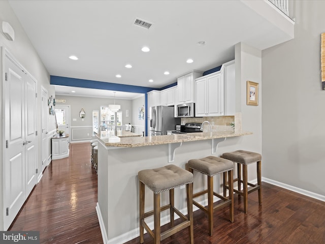 kitchen with light stone counters, decorative backsplash, stainless steel appliances, dark wood finished floors, and visible vents