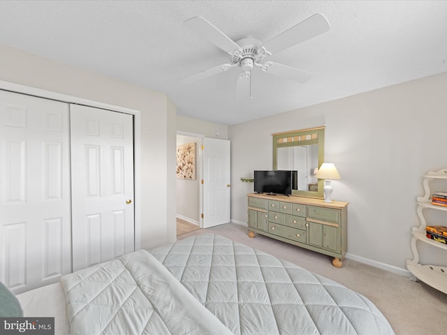 bedroom featuring ceiling fan, baseboards, a closet, and light colored carpet