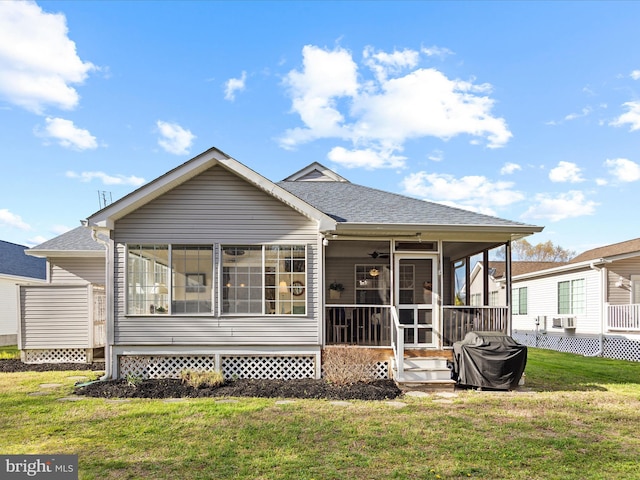 back of property with a shingled roof, a ceiling fan, a sunroom, and a yard