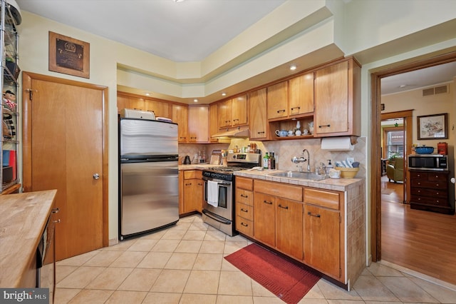 3257 Almond St, Philadelphia, PA 19134 - kitchen featuring a sink, light tile patterned flooring, appliances with stainless steel finishes, under cabinet range hood, and visible vents