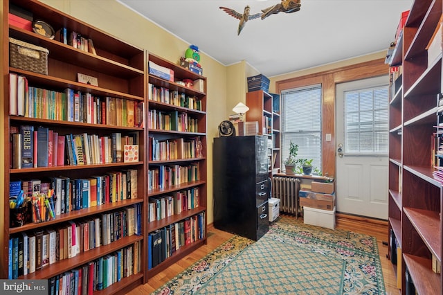 3257 Almond St, Philadelphia, PA 19134 - living area featuring radiator, wall of books, and wood finished floors