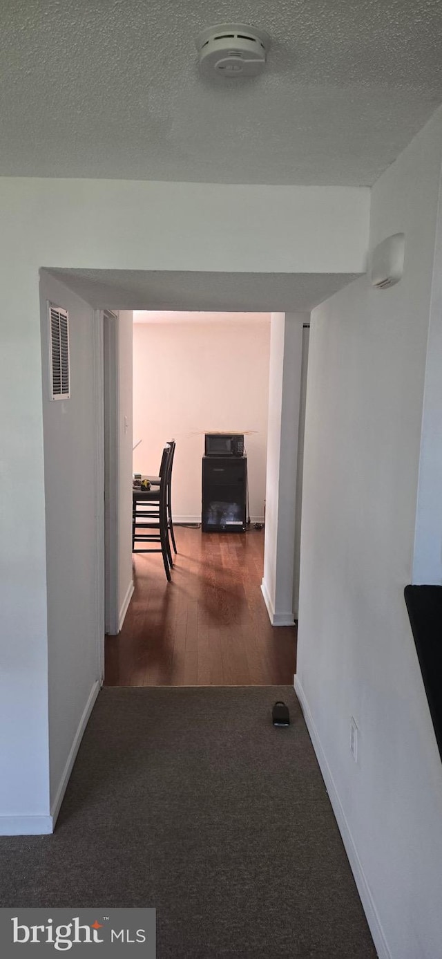 626 Felton Ave, Sharon Hill, PA 19079 - hall featuring wood finished floors, a textured ceiling, carpet, baseboards, and visible vents