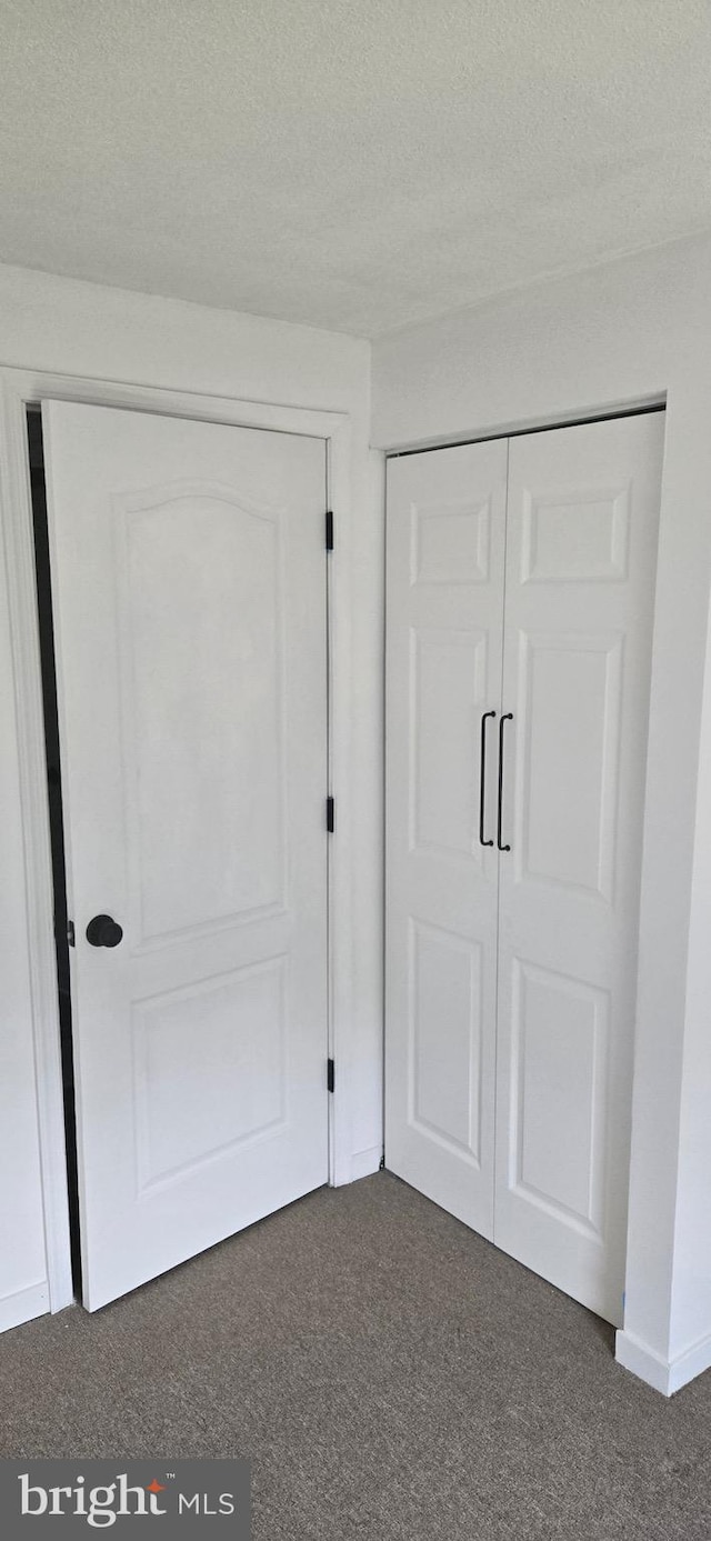 626 Felton Ave, Sharon Hill, PA 19079 - unfurnished bedroom with a textured ceiling, dark colored carpet, and a closet