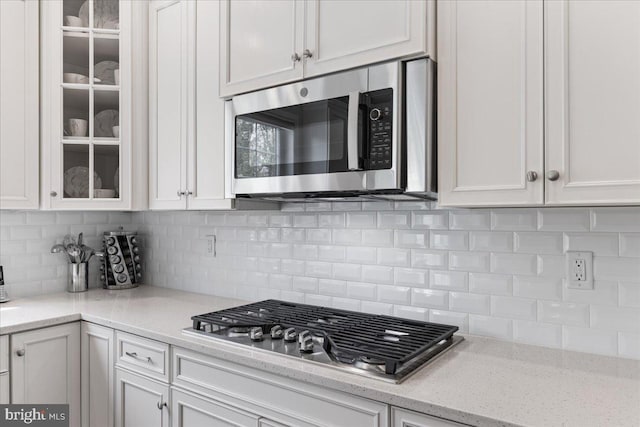 10815 Flying Change Ct, Upper Marlboro, MD 20772 - kitchen with backsplash, appliances with stainless steel finishes, white cabinetry, and glass insert cabinets