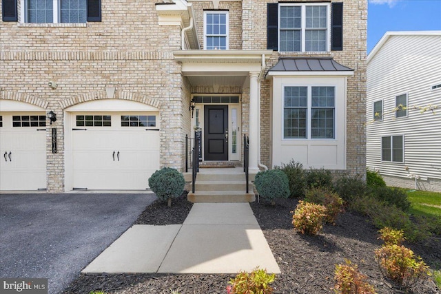 10815 Flying Change Ct, Upper Marlboro, MD 20772 - view of exterior entry with a standing seam roof, driveway, stone siding, metal roof, and a garage