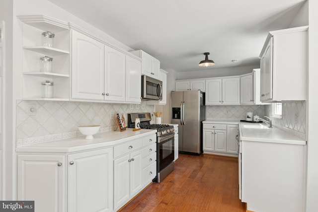 kitchen featuring stainless steel appliances, backsplash, and white cabinetry
