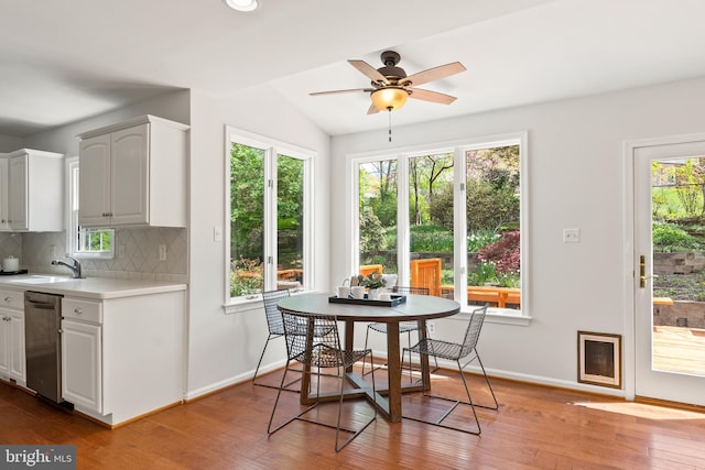 interior space with tasteful backsplash, wood finished floors, a sink, ceiling fan, and light countertops