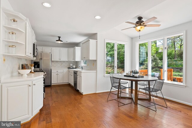 kitchen with white cabinetry, decorative backsplash, open shelves, light countertops, and appliances with stainless steel finishes