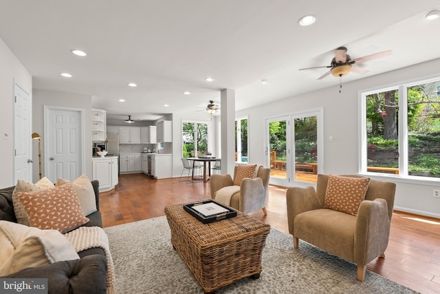 living area featuring baseboards, a ceiling fan, light wood-style floors, and recessed lighting
