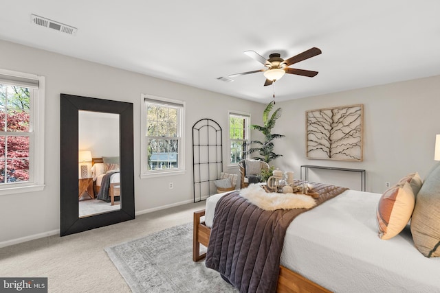 carpeted bedroom featuring baseboards, multiple windows, and visible vents