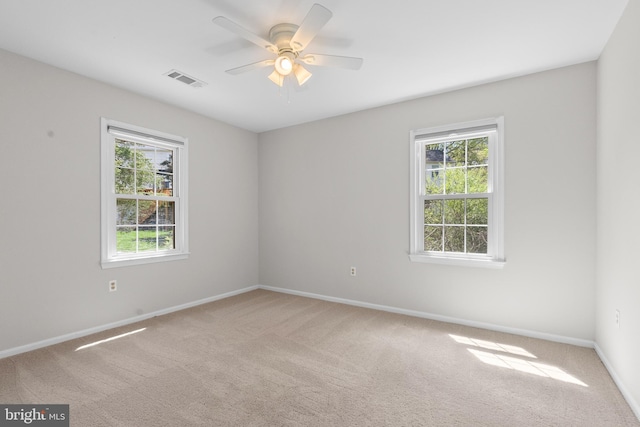 carpeted empty room with ceiling fan and baseboards