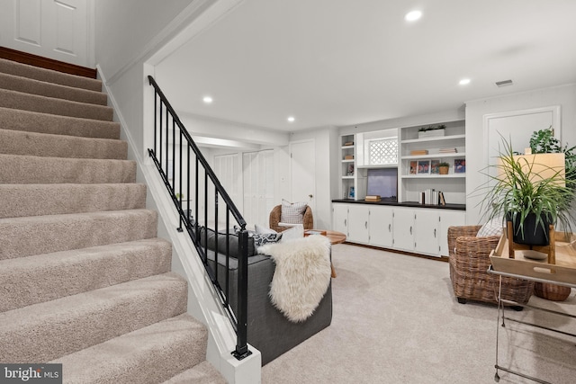 living area featuring visible vents, light colored carpet, recessed lighting, and stairway